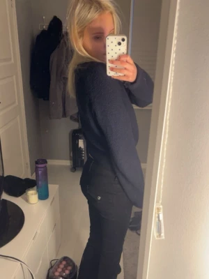 Svarta bootcut jeans med låg midja - Snygga svarta jeans med låg midja och bootcut passform. Klassisk femficksmodell med knapp- och dragkedjestängning. Perfekta för en trendig och avslappnad look.