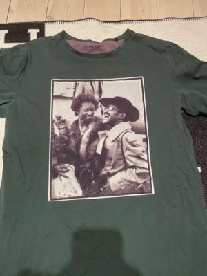 Grön t-shirt med tryck från Limitato - Cool grön t-shirt från Limitato med ett stort svartvitt fototryck på bröstet. T-shirten har rund hals och korta ärmar. Perfekt för dig som vill sticka ut med en unik design och konstnärlig vibe.