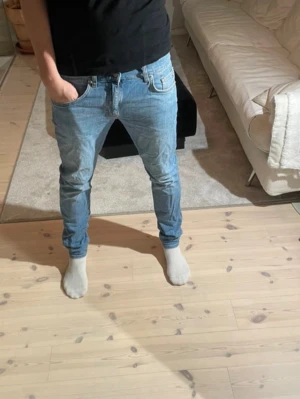 J.lindeberg slim fit jeans - Säljer ett par ljusblåa slim fit jeans från j.lindeberg med klassisk femficksdesign och normal midja. Jeansen har en snygg tvätt och raka ben. Passar perfekt till en avslappnad stil och är tillverkade i mjukt denimtyg. TVEKA INTE VID FRÅGOR! Pris kan diskuteras 