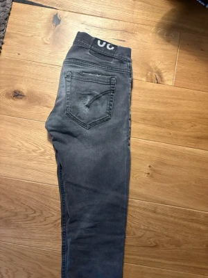 Grå slim fit jeans från dondup - Snygga grå slim fit jeans från dondup med knäppning framtill och klassiska fem fickor. Jeansen har en diskret tvättad look och logga på linningen bak. Perfekta för en avslappnad och trendig stil.