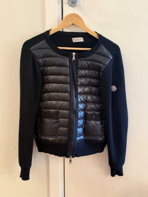 Svart cardiganjacka från Moncler - Säljer min svarta cardiganjacka från Moncler i storlek Smal. Jackan är i väldigt bra skick och inga anmärkningar. Självklart äkta. Skriv om du vill ha fler bilder. 