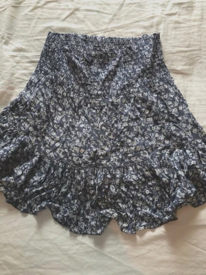 Blommig volangkjol från lager 157 - Supersöt kortkjol från lager 157 med blått och vitt blommönster. Stretchig och luftig kjol till sommaren.