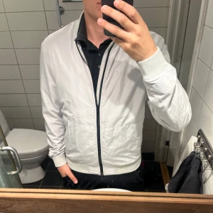 Wind Breaker J.Lindeberg - Stilren och tidlös jacka från J.Lindeberg i mycket fint skick. Klassisk design som funkar lika bra till vardag som lite uppklätt.  Storlek L men är något liten i modellen – skulle säga att den sitter som M  • Mycket bra skick • Original J.Lindeberg • Perfekt för våren • Rök- och djurfritt hem  Säljs pga garderobsrensning. | Pris 399kr |