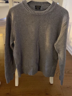 Grå stickad tröja från Massimo dutti  - Klassisk grå stickad tröja från Massimo dutti med rund halsringning och ribbade muddar vid ärmslut och nederkant. .