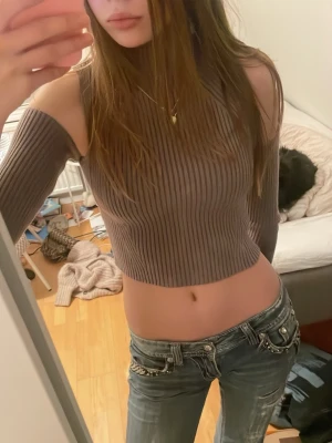 Ribbad brun croppad offshoulder topp - Säljer en skit cool ribbad brun croppad topp med offshoulder-design och lång är från Zara. Toppen har en tajt passform och hög hals, vilket ger en trendig och edgy look. Perfekt att styla med jeans eller kjol för en cool outfit.storlek s, den är lite nopprig på framsidan men inget man tänker på när man har den på.hör av dig om du har några frågor eller funderingar 💕