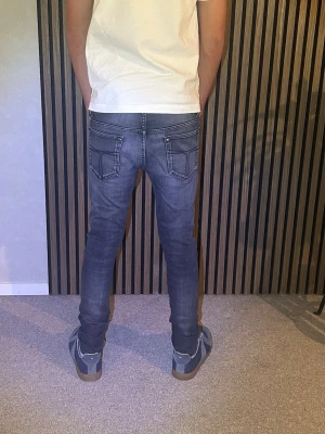 Mörkgrå jeans Tiger Of Sweden - Säljer ett par mörkgrå jeans ifrån TIGER OF SWEDEN. Jeansen har snygga sömdetaljer och har en smal passform som sitter tight längs benen. Materialet är stretchigt denim. Tveka inte vid frågor!