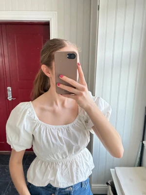 Vit blus med puffärmar  - Supersöt vit blus från Bik Bok med puffiga korta ärmar och resår i midjan. Säljer då den inte används längre, använd ett fåtal gånger🤍🤍🤍