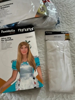 Alice i Underlandet maskeraddräkt - Komplett Alice i Underlandet-set med blå och vit klänning, blond peruk och vita strumpbyxor. Perfekt för cosplay eller maskerad. Klänningen har puffärmar och rosett, peruken är lång och rak.