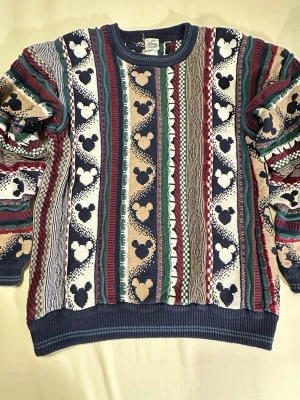 Collectible Vintage Disney Coogi-Style Chunky Heavy Knit Sweater - 90’s - Size Large - Vintage Disney knit - Coogi-style textured sweater. Chunky multi-pattern knit with raised stripes and woven Mickey silhouettes in navy, cream, beige, burgundy and green. Boxy relaxed fit with ribbed hem and cuffs. Great Y2K/streetwear vibe and perfect over baggy denim or cargos. Rare detailed Disney piece with real vintage character. See measurements in photos. Very good vintage condition.