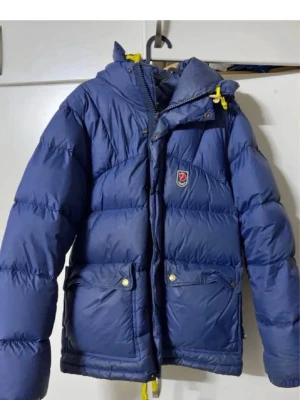 Blå Fjällräven Expedition dunjacka - Herr xs sitter som en s på en tjej