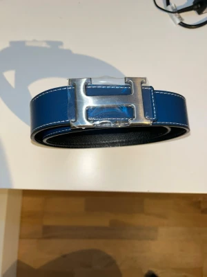 H3rm3s bälte med H - Snyggt blått skärp med H-logga. Storlek 110cm. Priset kan diskuteras.