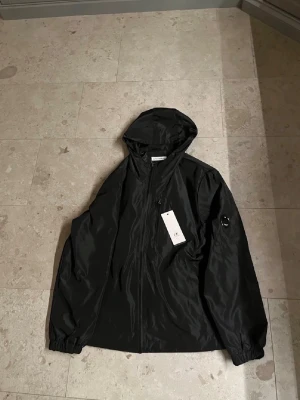 Cp company jacka - Säljer en svart cp company vindjacka. Jackan är i helt nytt skick aldrig använd. Den är i storlek xs-S                        Nypris 2599kr💸.                                    Kom privat vid frågor å funderingar😊