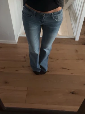 Blå bootcut jeans med låg midja - Säljer ett par ljusblå bootcut jeans med låg midja från Gina Tricot. Köpt från Vinted då de inte passade mig så jag säljer dem vidare. Innerbenslängd: 79 cm. Midjemått: 38 cm rakt över. Grenmått: 18,5 cm. Skriv vid frågor💗(de två första bilderna är lånade)
