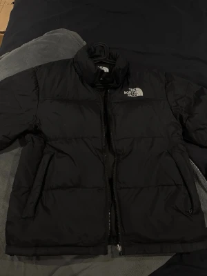  The North Face jacka. - Säljer en svart pufferjacka från The North Face. Jätte fint och fräsch. Jag har inte använt den på jättelänge. Den e jättefräsch som sagt men det går inte bara att tajta till annars är den perfekt.