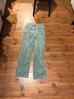 Gröna juicy couture byxor  - Gröna juicy couture byxor i storlek S. Har dock sytt upp en bit (se bild) passar mig som är 160cm. Man kan säkert sprätta upp dom om man vill. Jag tycket inte att man ser så mycket att dom är sydda. 