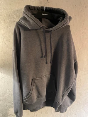 Grå hoodie från BikBok med huva - Mysig grå hoodie från BikBok i storlek XS. Hoodien har en ficka framtill, justerbar i huvan och ribbade muddar vid ärmar och nederkant. Tillverkad i mjukt sweatshirtmaterial som är borstat på insidan för extra komfort.