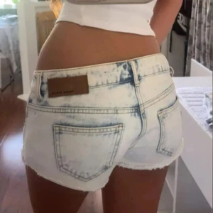 Lowwaist mini jeansshorts med vit brodering - Snygga low waist mini jeansshorts i strl 38, midja:39cm. Kommer fler unika jeansshorts/kjolar så följ!!