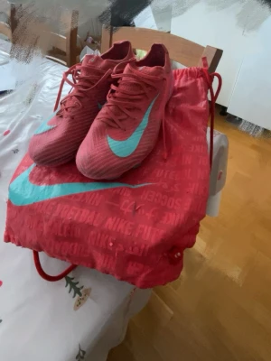 Nike Mercurial rosa fotbollsskor - Säljer ett par Nike Mercurial fotbollsskor. I färgen röd med turkos design . Str 42 inget fel på skorna säljer pga att dom e för små. Pris kan diskuteras!!!