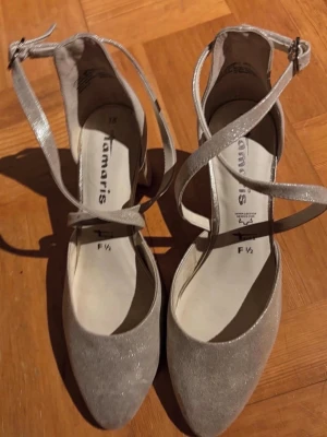 Tamaris Pumps, Guld, Storlek 38  - Eleganta glitter sandaletter från Tamaris i storlek 38. Perfekt för festliga tillfällen. Är mycket mycket smått använda. Hämtas på Södermalm i Stockholm eller skickas till dig. Du bestämmer. Maila mig vid frågor. Med vänlig hälsning, Fanny