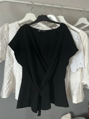 Svart omlottopp från Zara - Svart omlotttopp från Zara med fin passform och mjukt, följsamt tyg. Passar både till vardag och fest