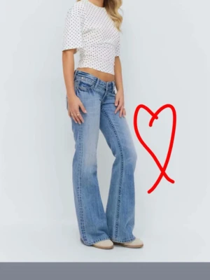Gina Young 14+ bootcut jeans - Säljer ett par ljusblå bootcut jeans med låg midja och klassiska fem fickor. Den är från Gina tricot.  Jeansen har en avslappnad passform och är tillverkade i denim med snygga slitningar. Perfekta för en trendig och avslappnad look. Gina Young