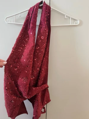 Glittertopp - Rosa glittrig topp från BikBok. Omlott framtill med ett band vägrätt i ryggen. Endast använd vid ett tillfälle. Har klippt av banden som används för att hängas i då de syns vid användning.. 