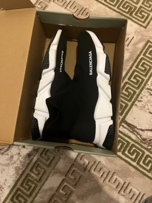 Balenciaga Speed Trainer svarta sneakers - Svarta Balenciaga Speed Trainer sneakers med vit chunky sula och stickad ovandel i textil. Strumpmodell med logga på sidan och svart/vita detaljer på sulan. Superlätta och flexibla för en modern look.