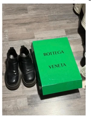 Svarta boots från Bottega Veneta - Chunky svarta boots från Bottega Veneta i slätt läder med elastiska paneler på sidorna och kraftig gummisula. Klassisk siluett med modern twist och dragflik bak. Perfekta för dig som vill ha en statement-look.