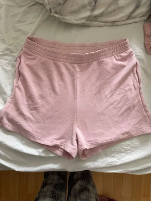 Ljusrosa shorts från H&M Divided - Säljer ett par ljusrosa shorts från H&M Divided med elastisk midja och sidofickor. De är gjorda i mjuk bomullsblandning och har en avslappnad passform, perfekta för sommardagar eller chill hemma. Tveka inte på att höra av dig om du har några frågor!💕svarar snabbt