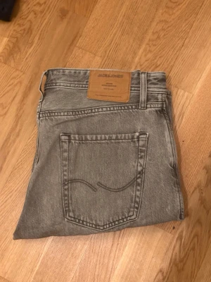 Grå jeans från Jack & Jones - Snygga grå jeans från Jack & Jones med klassisk femficksdesign och raka ben. Jeansen har en ljusgrå tvätt och är tillverkade i bomull med en skön passform. Perfekta för en avslappnad och trendig stil. Dm:a gärna för fler bilder.😄💯W31 L32