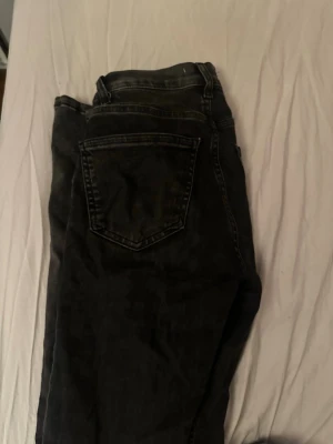 Svarta jeans från Gina tricot - Säljer ett par svarta jeans från Perfect Jeans i storlek 32. Klassisk femficksmodell med raka ben och normal midja. Jeansen har en snygg tvättad look och är tillverkade i mjukt denimtyg. Perfekta till vardagsoutfiten!