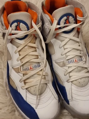 Air Jordan 8 Retro vit/blå/orange - Säljer ett par Air Jordan 8 Retro sneakers i vitt, blått och orange. Skorna har högt skaft, klassisk Jordan-logga på plösen och vadderad insida i orange. 