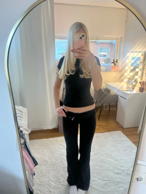 Svarta low waist bootcut kostymbyxor  - Säljer ett par svarta low waist kostymbyxor med bootcut-modell. Kostymbyxorna har knäppning fram. Snygg passform som sitter lågt på höften och ger en trendig Y2K-vibe. Perfekta för dig som gillar en retro och avslappnad stil.