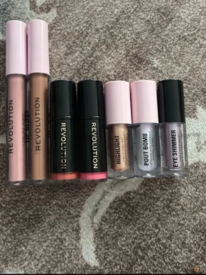 Läppstift och gloss från Revolution - Säljer ett set med flera läpprodukter från Revolution. Innehåller två läppglans i nude och rosa toner, två klassiska läppstift i korall och rosa, samt ett skimrande läppglans. Alla har snygga förpackningar i svart och rosa plast. Perfekt för dig som vill variera din look.