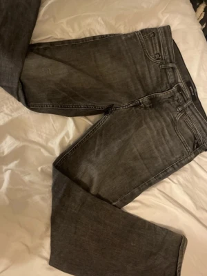 Svart Gråa jeans från Replay - Säljer ett par snygga svart gråa jeans från Replay med klassisk femficksmodell och raka ben. Jeansen har cool tvätt och detaljerade sömmar. Perfekta för dig som vill ha en stilren men avslappnad look.