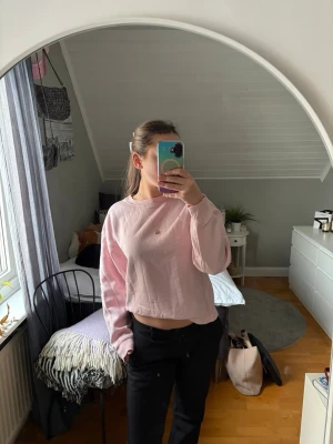 Ljusrosa sweatshirt med rund hals - Ljusrosa sweatshirt med rund hals och långa ärmar. Tröjan har en avslappnad passform och är gjord i mjukt material, perfekt för en chill look. Inga synliga loggor eller mönster, enkel och stilren design.