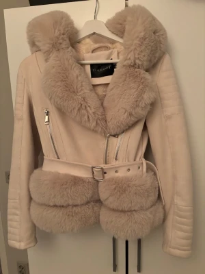 Pälskappa  - Beige kappa med fuskpäls & luva  i storlek S (passar mig som har storlek xs). Knappt använd 🌸 