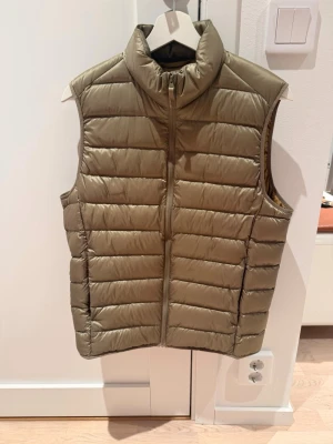 Uniqlo väst - Uniqlo dunväst i grön. Köptes i somras aldrig använd. Storlek S