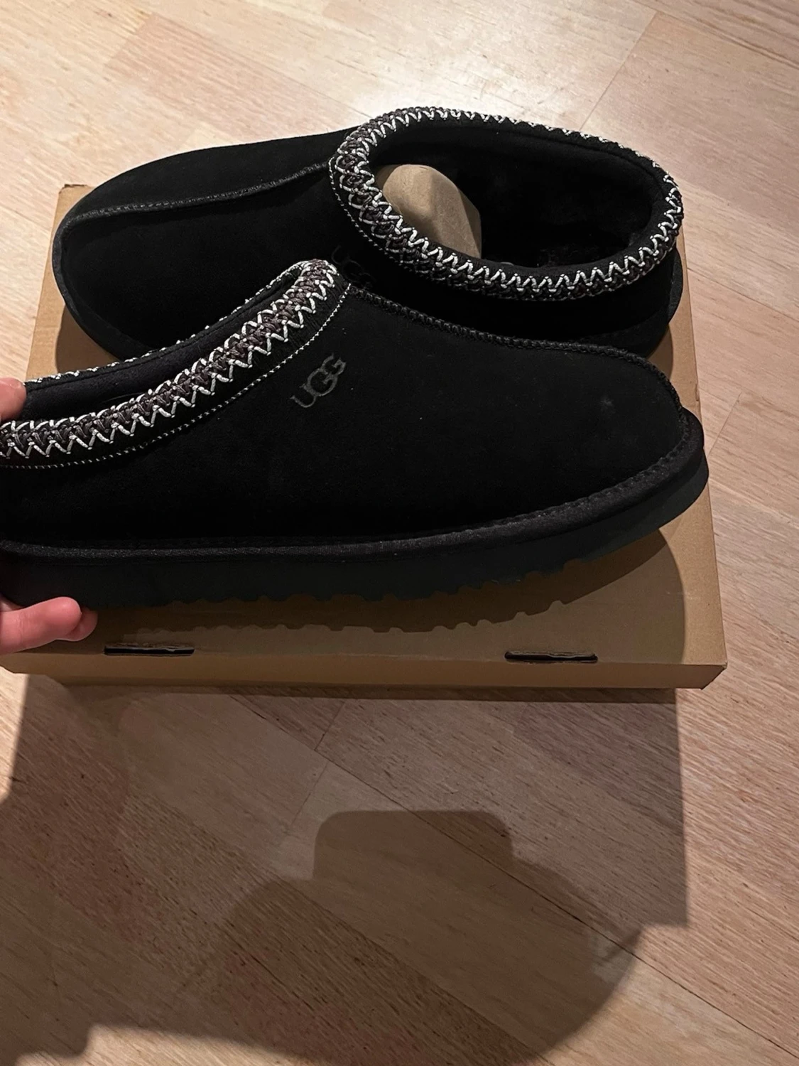 Svarta UGG tofflor med mönstrad kant