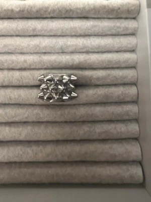 Silverring Edblad  - Stilren ring i silverfärg med små nitdetaljer runt halva bandet. Perfekt accessoar för att ge din look en elegant touch. Passar att kombinera med andra smycken för en personlig stil.