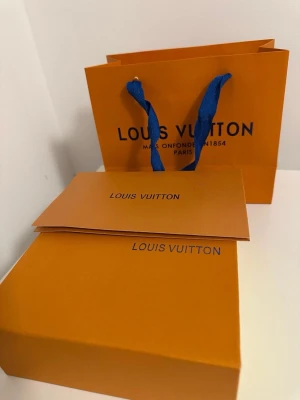 L.V svart bälte med L.V-spänne - Snyggt svart bälte från L.V med klassiskt L.V-monogram och ett stort silverfärgat L.V-spänne. Bältet kommer i originalförpackning med dustbag och presentpåse. Perfekt accessoar för att lyfta vilken outfit som helst.