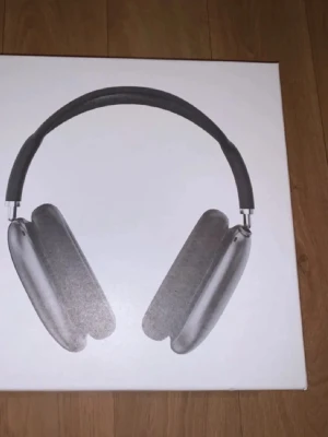 Apple AirPods Max hörlurar svart - Snygga Apple AirPods Max i svart med over-ear design och mjuka öronkuddar. Bygeln är vadderad och bågen i metall ger en exklusiv känsla. Hörlurarna har ett stilrent utseende och levereras med ett matchande svart skyddsfodral.