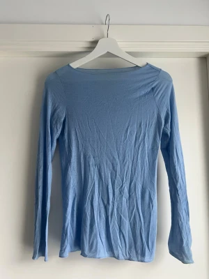 Ljusblå långärmad topp Intimissimi - Superskön ljusblå långärmad topp från Intimissimi i en tunn och mjuk mix med kashmir. Enkel och stilren design med rund halsringning, perfekt att styla till jeans eller kjol.