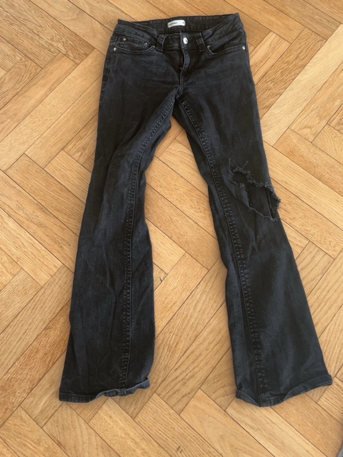 Svarta bootcut jeans med slitning
