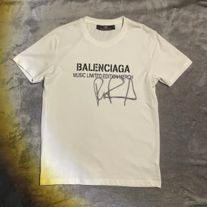 Vit limited edition t-shirt - Vit t-shirt med trycket 'MUSIC LIMITED EDITION MERCH' och en stor signatur på framsidan. Klassisk rund hals och korta ärmar. Perfekt för dig som gillar exklusiva och trendiga plagg från kända märken. Endast använd 1 gång