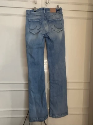 Ljusblå bootcut jeans från LTB - Säljer ett par ljusblå bootcut jeans från LTB med klassiska bakfickor och snygga slitningar. Jeansen har normal midja, och är mid rise boothcut. De är storlek 27/34. Perfekta för en vanlig vardag eller finare tillfällen. Kan upplevas lite ”hårda” men de behövs bara tvättas med skölj medel så blir det nog bra! Har inte tvättat de sen jag fick dem och de var för långa 💕