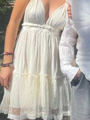 Vit klänning med öppen rygg - Säljer en vit klänning med v-ringad front och öppen rygg. Storlek S🙏