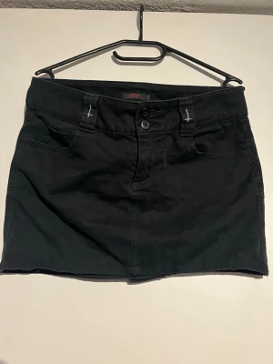 Gothic Svart kortkjol från One🖤 - Svart kortkjol från One med klassisk femficksdesign🖤 med kors på looparna🖤