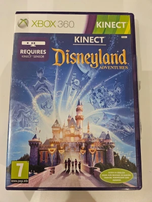 Disneyland Adventures till Xbox 360 Kinect - Disneyland Adventures till Xbox 360 Kinect tar dig till en magisk värld fylld av klassiska Disney-karaktärer och äventyr. Spelet har ett blått fodral med färgglad illustration av Disneyland-slottet och flera Disneyfigurer. Kräver Kinect-sensor för att spela.