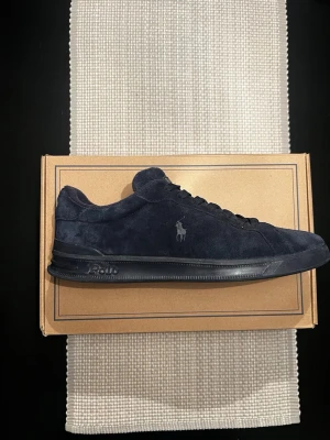 Mörkblå Polo sneakers i mocka - Snygga mörkblå sneakers från Polo i mjuk mocka med matchande mörkblå skosnören och svart sula. Klassisk låg modell med Polo-logga i guld på plösen. Perfekta för en clean och stilren look bild på skolådn kommer med pris kan diskuteras nypris 1845kr🫡😊